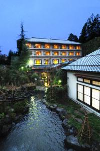 a hotel with a river in front of a building at Wakatake in Tagami
