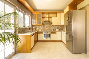 a kitchen with stainless steel appliances and a large window at Erofili's Apartment ONLY 700 meters from the beach in Ialysos