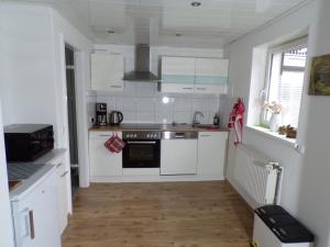 a kitchen with white appliances and a wooden floor at Ferienwohnung Nussbaum Sendenhorst in Sendenhorst