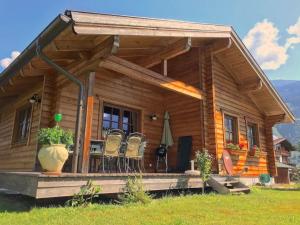 a log cabin with a porch and chairs on it at gemütliches Tiroler Blockhaus in Aschau