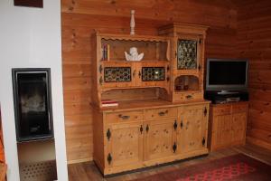 a living room with a tv and a wooden cabinet at gemütliches Tiroler Blockhaus in Aschau