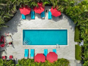 una vista aérea de una piscina con sombrillas rojas en The Locale Hotel Grand Cayman en George Town