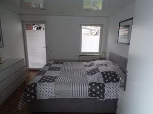 1 dormitorio con 1 cama con edredón blanco y negro en Ferienwohnung Nussbaum Sendenhorst, en Sendenhorst