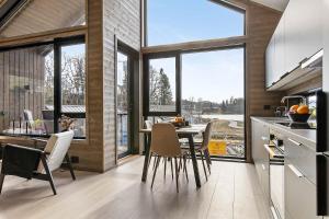 a kitchen with a table and chairs and windows at Egersund Overnatting in Egersund