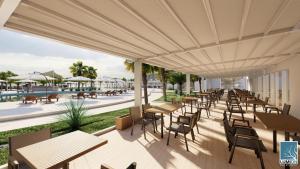 un patio extérieur avec des tables et des chaises ainsi qu'une piscine dans l'établissement Gadileh Resort Hotel, à Djibouti