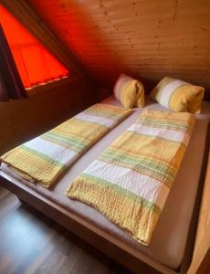 2 Betten in einem kleinen Zimmer in einer Hütte in der Unterkunft Faakersee - Familyhouse - mit PrivatStrand- Only Sa-Sa in Egg am Faaker See
