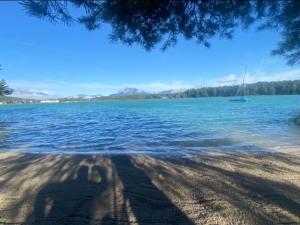 a shadow of a person on the shore of a lake at Faakersee - Familyhouse - mit PrivatStrand- Only Sa-Sa in Egg am Faaker See