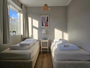 2 łóżka pojedyncze w pokoju z oknem w obiekcie Hótel Laugarvatn w mieście Laugarvatn