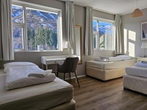 sypialnia z 2 łóżkami, biurkiem i oknami w obiekcie Hótel Laugarvatn w mieście Laugarvatn