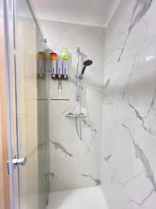 uma casa de banho com chuveiro e mármore branco em La cossonade em Menton