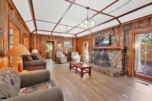 a living room with a stone fireplace in a house at Lodge House-Family Cabin with Pool Table by Big Bear Vacations in Big Bear Lake