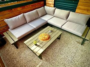 a white couch and a table with a pie on it at BREZA mobile house BIG BERRY in Metlika