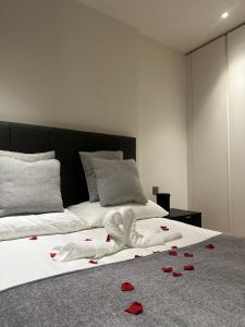 Una cama con pétalos de rosa roja. en Luxury Apartment - 2 minute walk from the O2 Arena en Londres