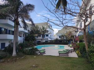 ośrodek z basenem z ławkami i palmami w obiekcie Residence Amanda with pool w mieście Santa Maria