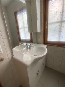 a white bathroom with a sink and a window at Faakersee - Familyhouse - mit PrivatStrand- Only Sa-Sa in Egg am Faaker See