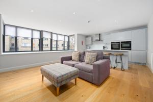 a living room with a couch and a stool at White Hart Hotel & Apartments in Harrogate