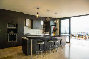 a kitchen with a counter with bar stools in it at Villa Los tres Diamantes in Copacabana