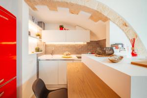 a kitchen with white cabinets and an archway at Bianca Relax & SPA - Housea in Polignano a Mare