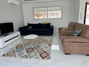 a living room with a couch and a table at Superbe villa avec piscine sans aucun vis à vis in Djerba