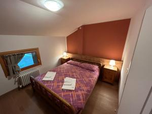 Habitación pequeña con cama y ventana en Residenza Sertorelli, en Bormio