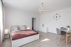 1 dormitorio blanco con 1 cama, mesa y sillas en Lizo2 3 csillagos apartman modern stílusban en Székesfehérvár