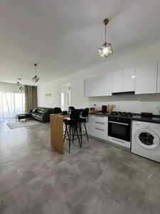 a kitchen and living room with a table and chairs at Caesar Resort & SPA Commodus in Iskele