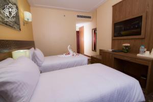 Postel nebo postele na pokoji v ubytování Manarat Gaza Hotel - Al Haram Tower
