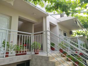 a house with white railing and potted plants at ERA Studios2 in Skiathos