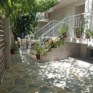 a house with stairs and potted plants on it at ERA Studios in Skiathos