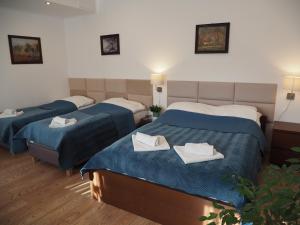 a hotel room with three beds with towels on them at Dom Gościnny 8 km od Suntago, Deepspot in Radziejowice