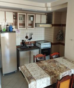 a small kitchen with a table and a refrigerator at Só alegria Eldorado Thermas in Caldas Novas