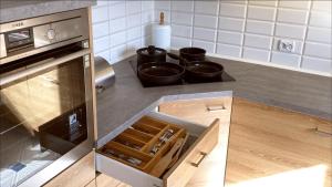 kuchnia z kuchenką oraz garnkami i patelniami w obiekcie Eleganckie Mieszkanko na Kamiennej Górze w mieście Gdynia