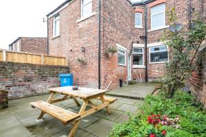 a wooden picnic table in front of a brick building at *Entire* 5 Bedroom house near football sleeps 8 in Liverpool
