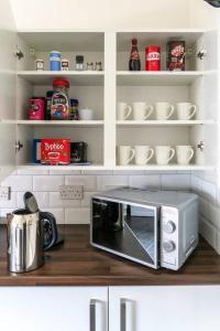 a microwave oven sitting on top of a kitchen counter at *Entire* 5 Bedroom house near football sleeps 8 in Liverpool