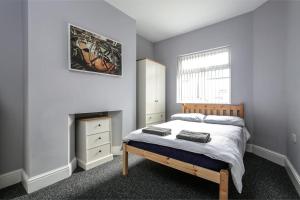 a bedroom with a bed and a fireplace and a window at 5 bedroom house, free parking, near football, sleeps 8 in Liverpool