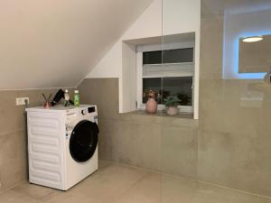 uma máquina de lavar roupa na casa de banho com uma janela em Luxspace Apartment Hagen em Hagen