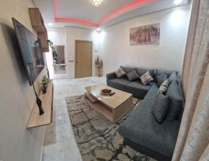 - un salon avec un canapé bleu et une table dans l'établissement Zenata ocean park appartement, à Mohammedia