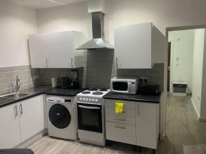 a kitchen with a stove and a microwave at One bedroom Apartment in Cardiff City Centre in Cardiff