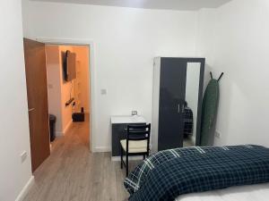 a bedroom with a bed and a desk with a chair at One bedroom Apartment in Cardiff City Centre in Cardiff