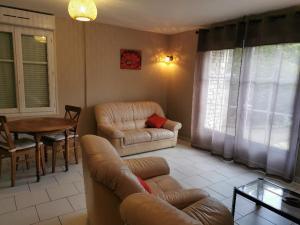 un soggiorno con divano e tavolo di BIENVENUE CHEZ NOUS a Ver-sur-Mer