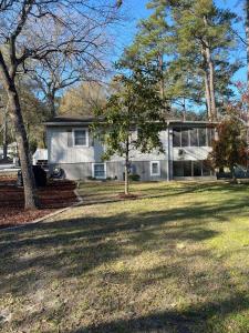 uma casa com um grande quintal em frente em Tipsea Turtle em Ocean Isle Beach