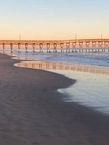 a pier stretches out into the water on the beach at Tipsea Turtle in Ocean Isle Beach