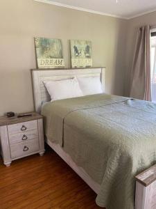 a bedroom with a bed and a nightstand and a window at Tipsea Turtle in Ocean Isle Beach
