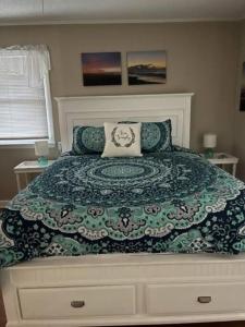 a bedroom with a bed with a green and white comforter at Tipsea Turtle in Ocean Isle Beach