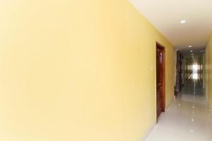 a hallway with a white wall and a door at Collection O Sree Guru Lakshmi Residency in Tirupati