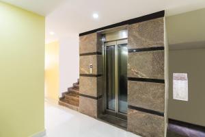 a elevator lobby with a wall of stone tiles at Collection O Sree Guru Lakshmi Residency in Tirupati