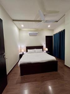 um quarto com uma cama e uma ventoinha de tecto em Serenity Corner em Islamabad