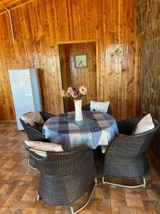een tafel met stoelen en een vaas met bloemen erop bij Bella cabaña sector residencial in Pelluhue