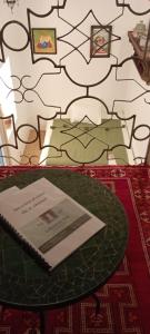 - une table avec un livre au-dessus d'un lit dans l'établissement La Maison des Amis, à Fès