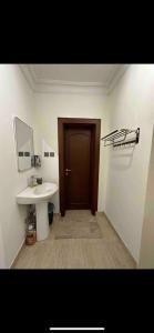 a bathroom with a sink and a mirror and a door at استديو بتصميم عصري ومريح في موقع مميز in Riyadh